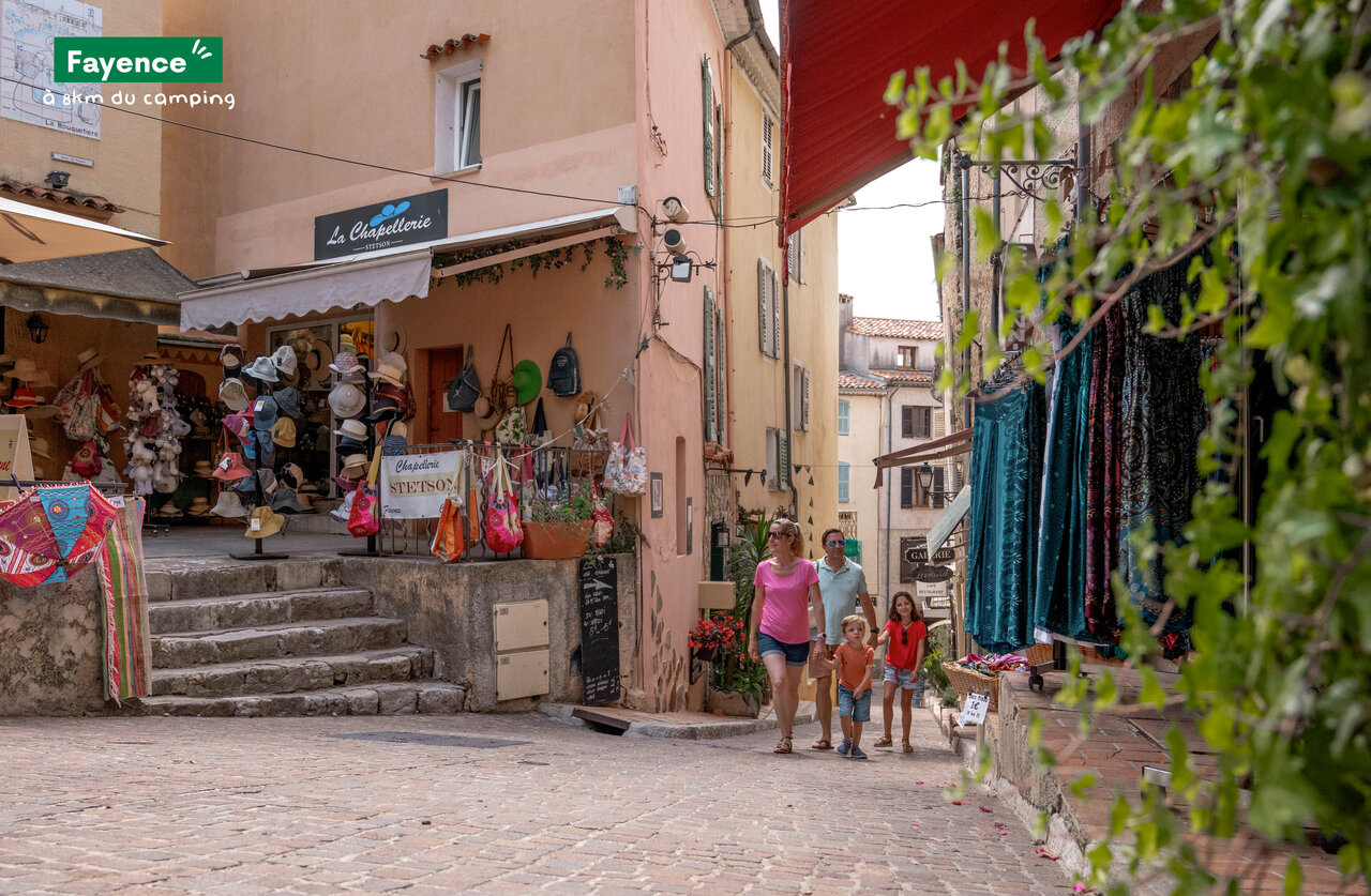 Familie spaziert durch malerische Einkaufsstra�e in Fayence, Provence.
