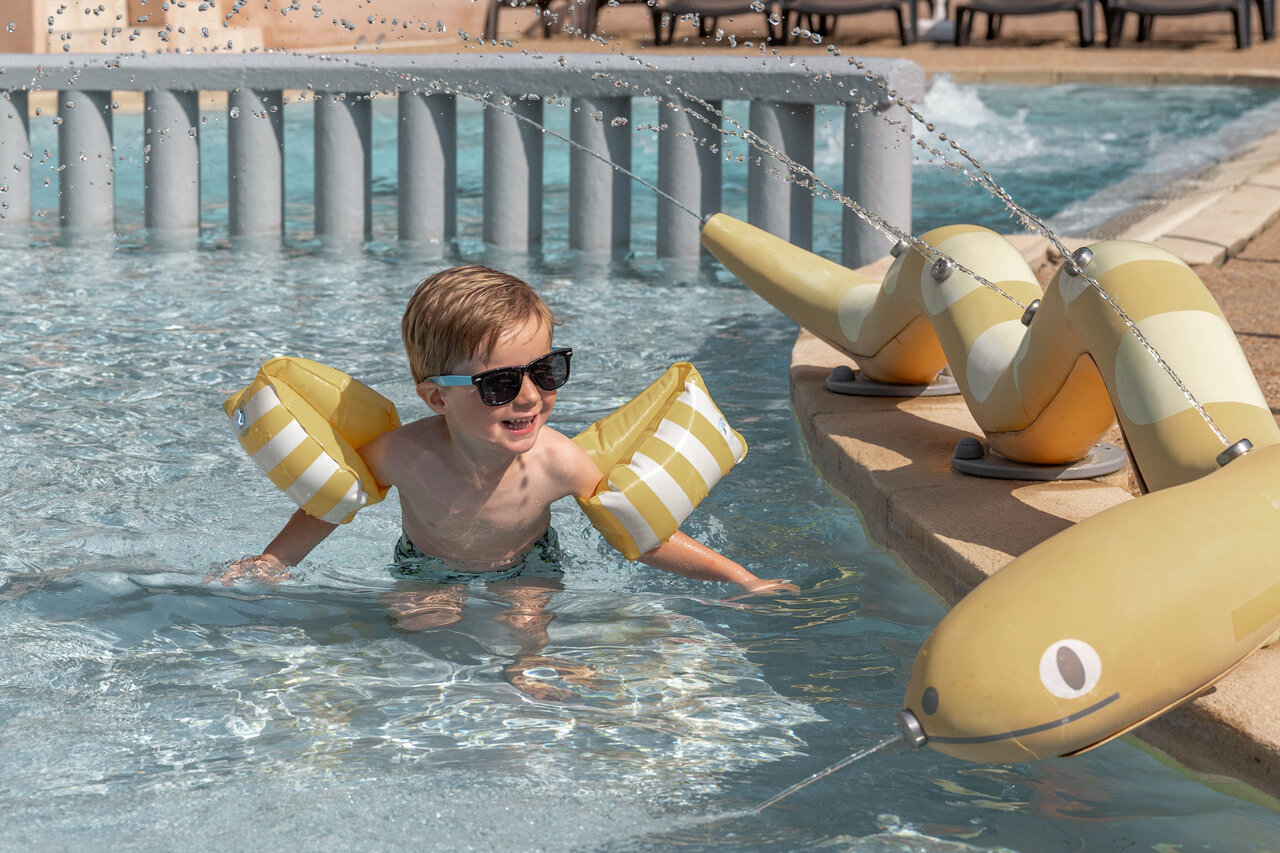 Lachendes Kind mit Schwimmfl�geln, Wasserspiele Pool Camping CLICOCHIC Lou Cantaire Fayence.