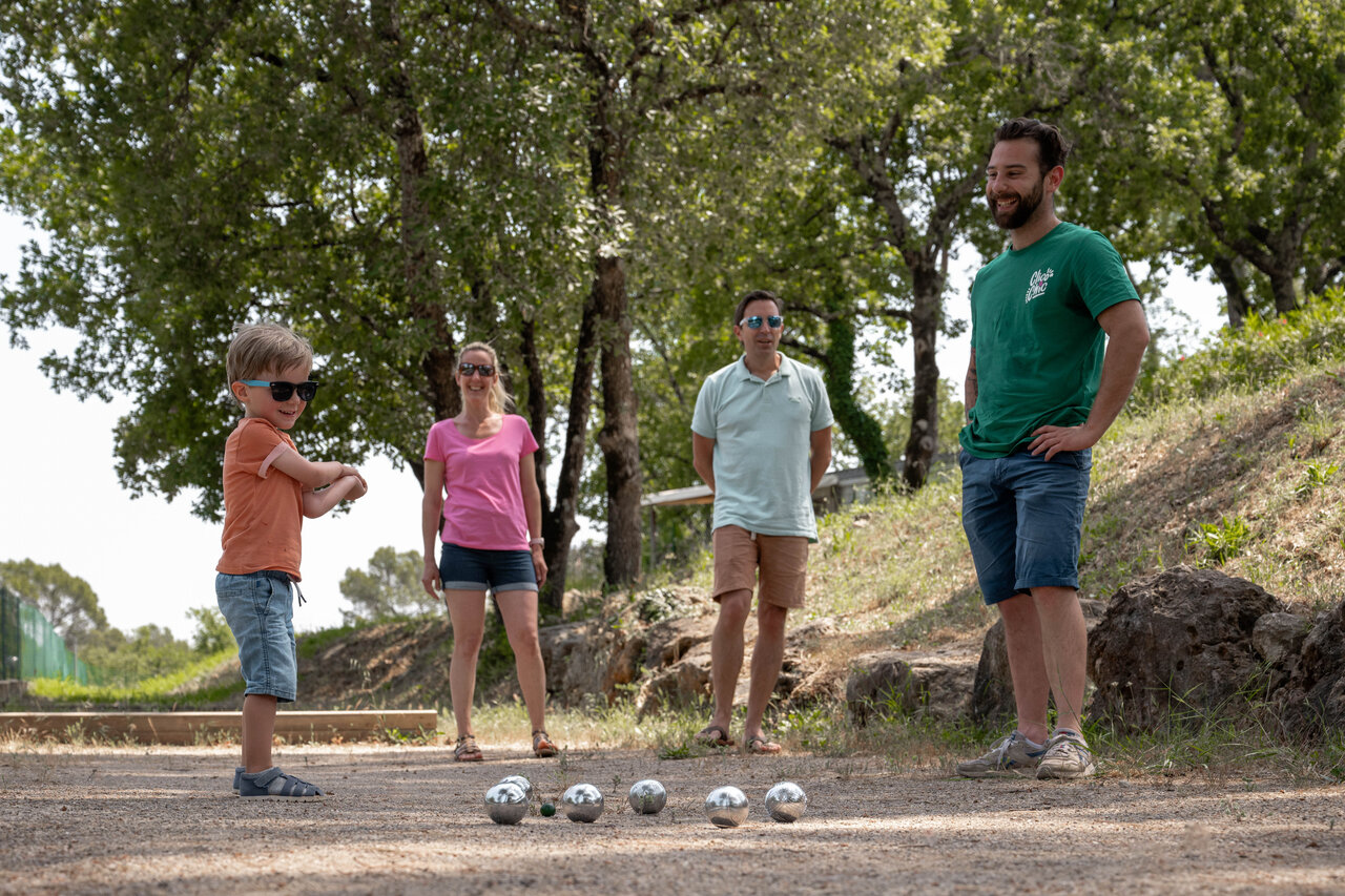 Familie spielt Boule auf einem schattigen Platz auf dem Campingplatz CLICOCHIC Lou Cantaire in FAYENCE (83).