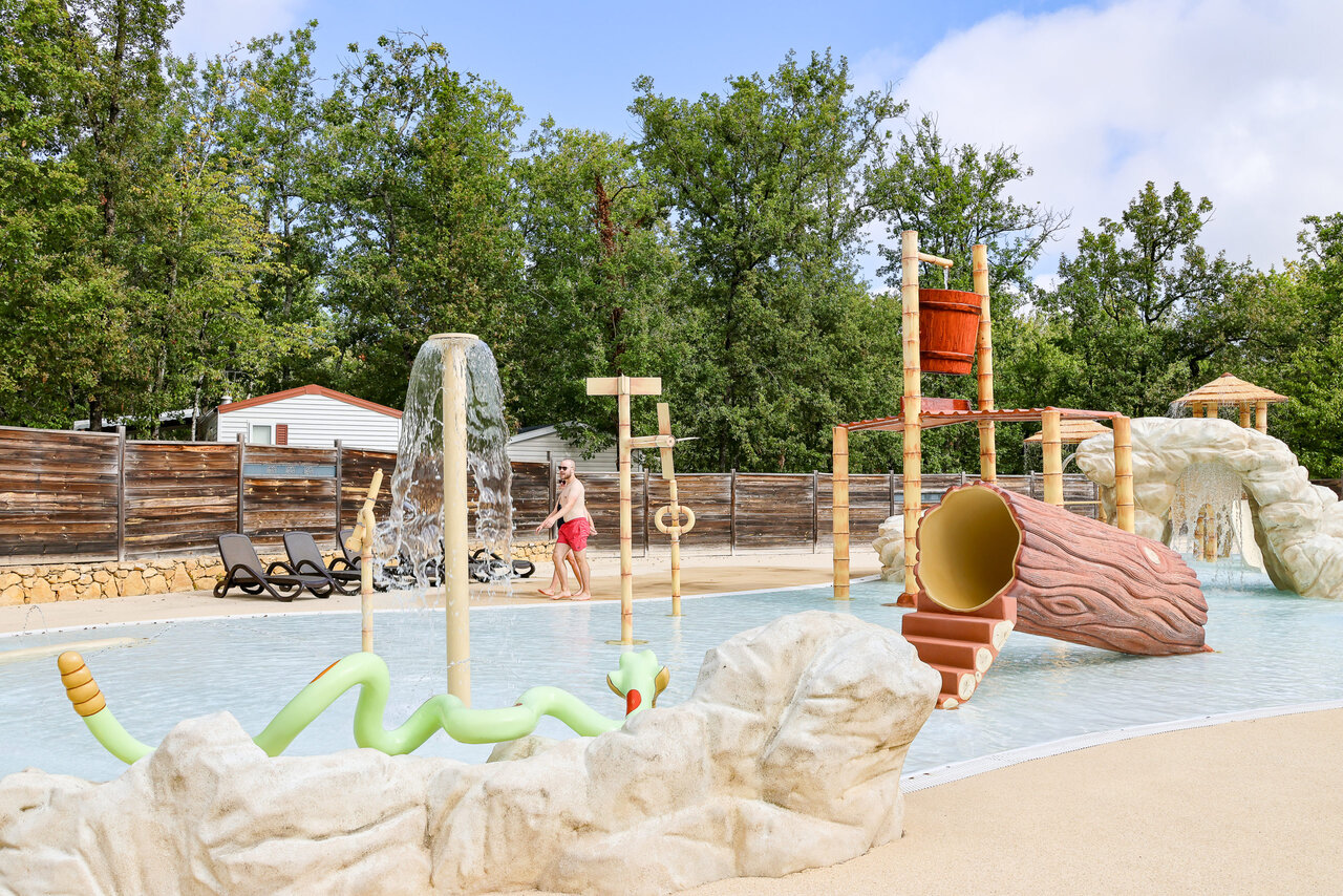 Water play area with slide and tipping bucket at CLICOCHIC Lou Castel campsite.
