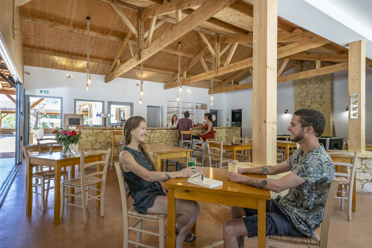 Modern indoor bar and restaurant at CLICOCHIC Lou Castel campsite in Castelnaud-la-Chapelle (24).