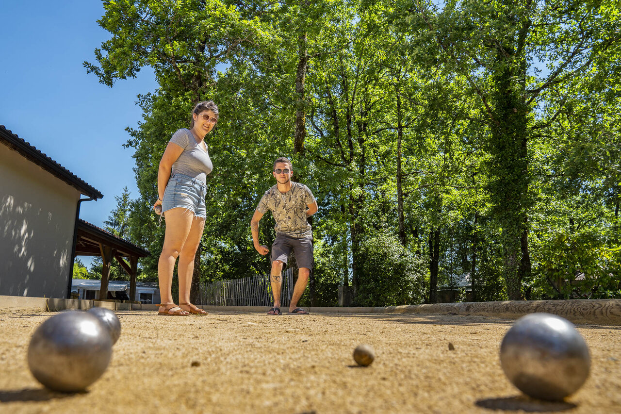 Lively p�tanque game on the court at CLICOCHIC Lou Castel campsite in Castelnaud-la-Chapelle.