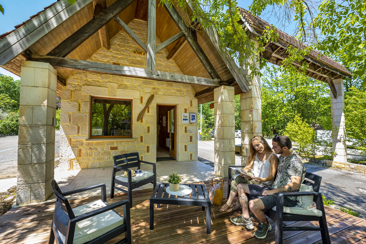 Reception area with outdoor terrace at CLICOCHIC Lou Castel campsite in Castelnaud-la-Chapelle.