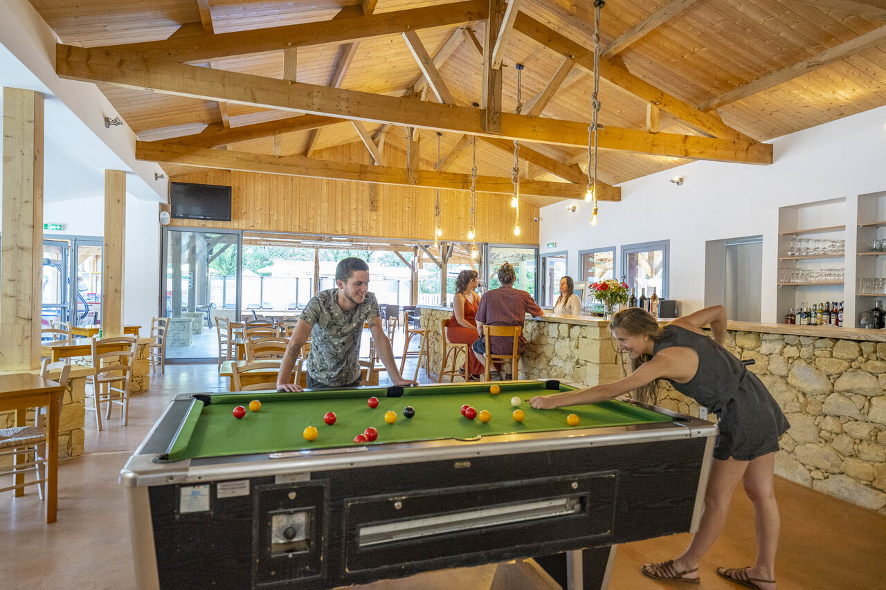 Billiards game and friendly bar atmosphere at camping CLICOCHIC Lou Castel in Castelnaud-la-Chapelle (24).