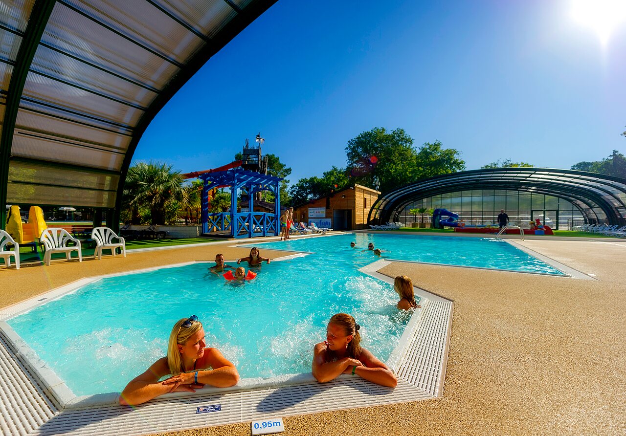 Aquatic area with jacuzzi, slide and covered pool at CAPFUN Lou Puntaou campsite in LEON (40).