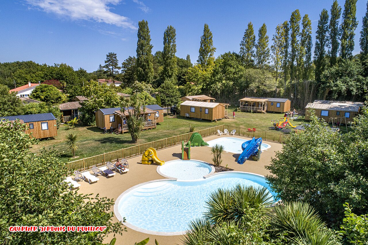 Outdoor pool, slides, Mobile homes, playground at CAPFUN Lou Puntaou campsite.