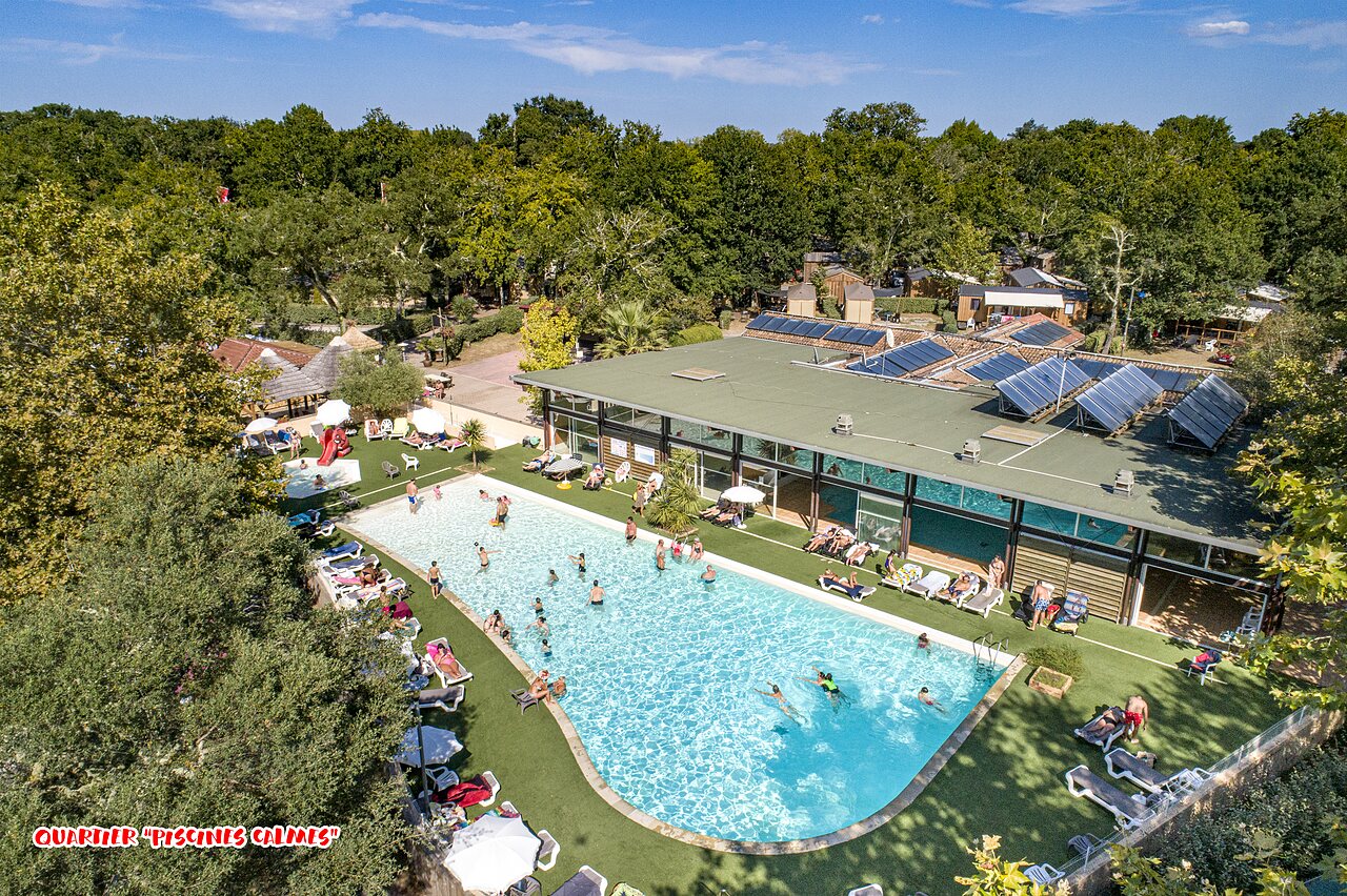 Outdoor swimming pool, slide, and solarium at CAPFUN Lou Puntaou campsite in LEON (40).