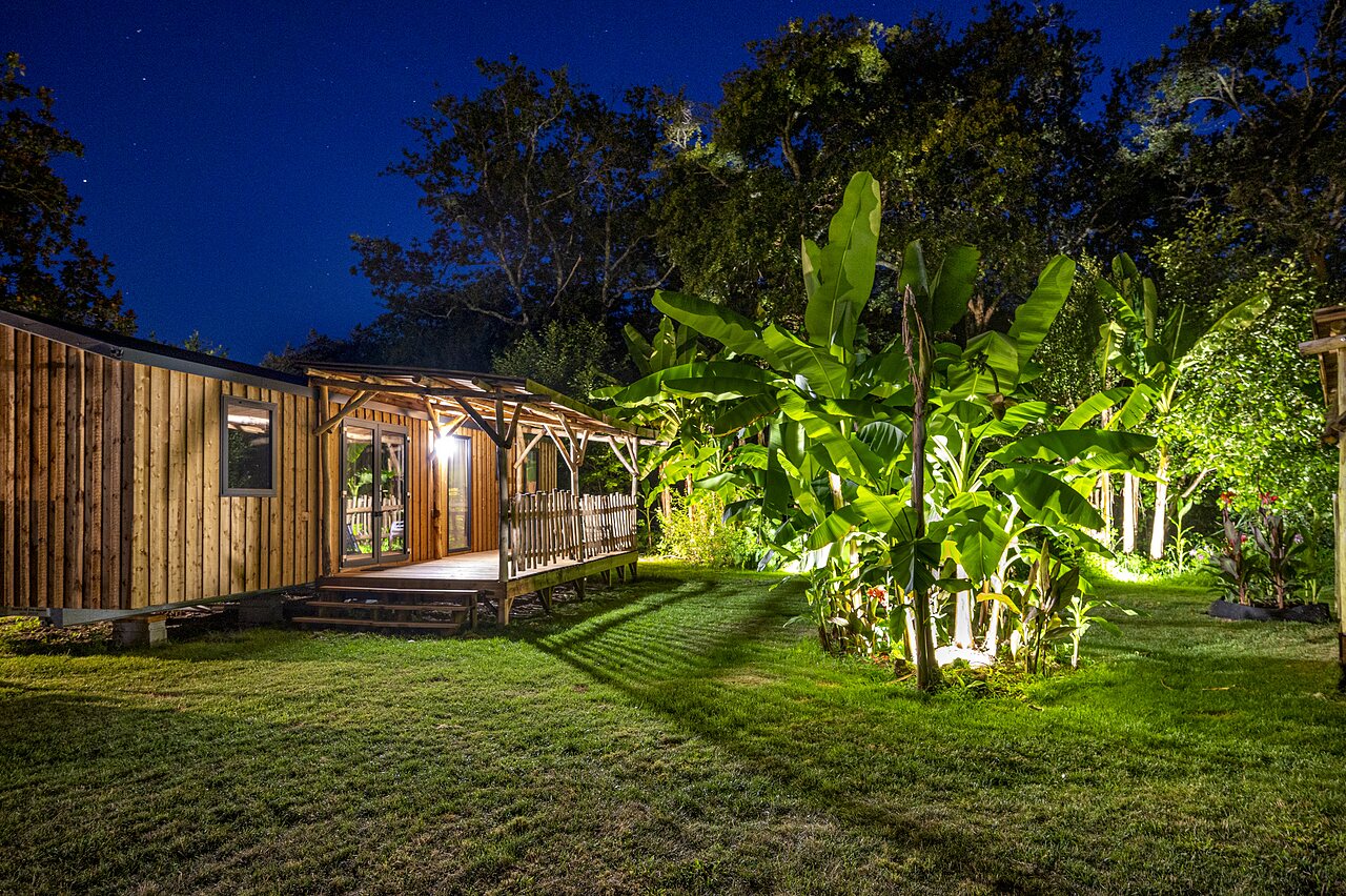 Wooden Mobile home, illuminated terrace, night, at CAPFUN Lou Puntaou campsite in LEON (40).