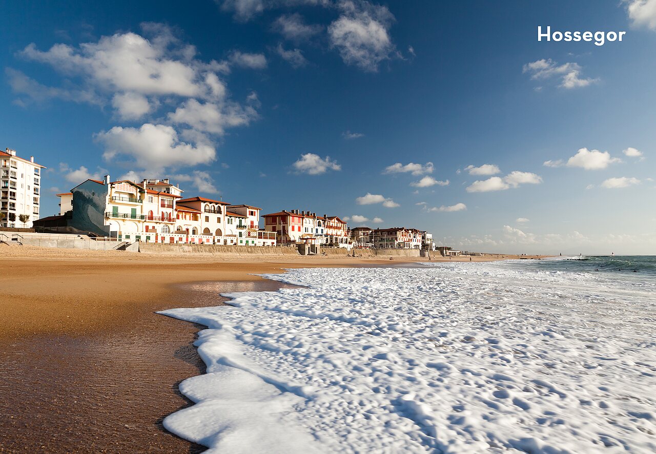 Hossegor beach with waves and typical buildings of the Landes coast.