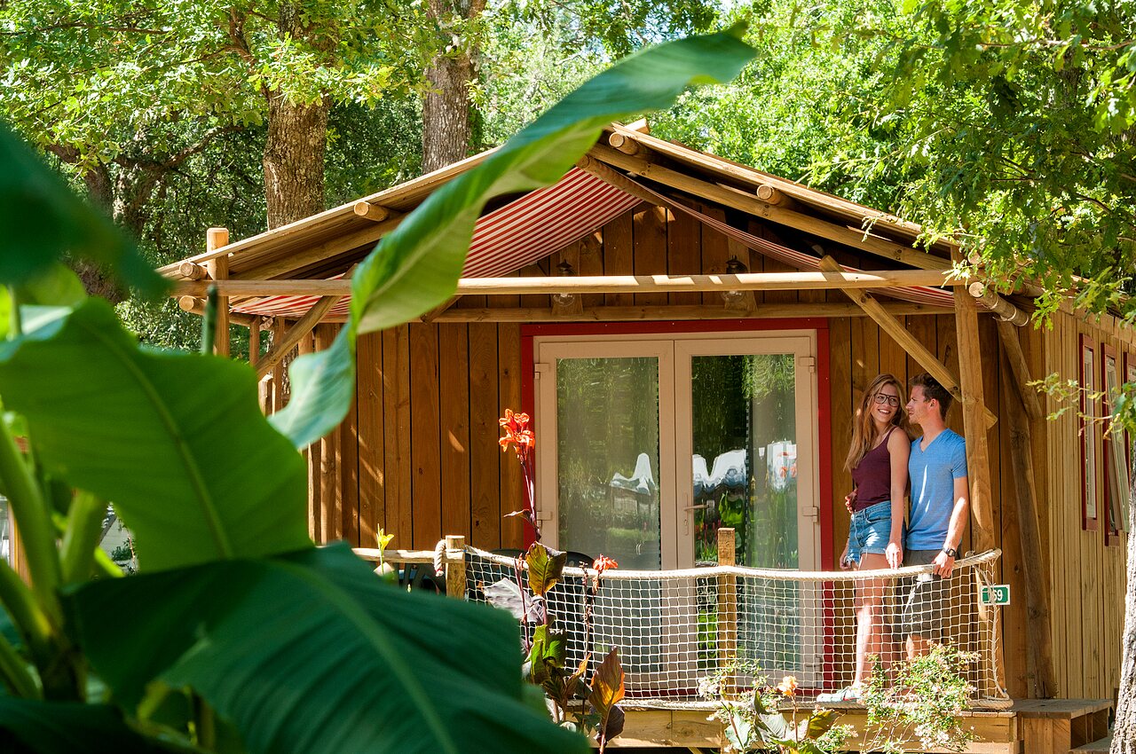 Smiling couple on wooden mobile home terrace, CAPFUN Lou Puntaou in LEON (40).