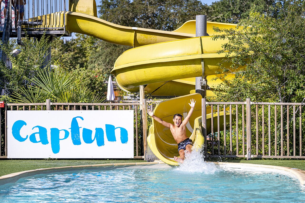 Happy child on yellow water slide, pool, CAPFUN Lou Puntaou in LEON (40).