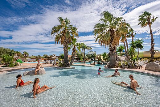Außenpool, Wasserrutsche und Palmen auf dem Campingplatz CAPFUN Lou Village in Vendres (34).
