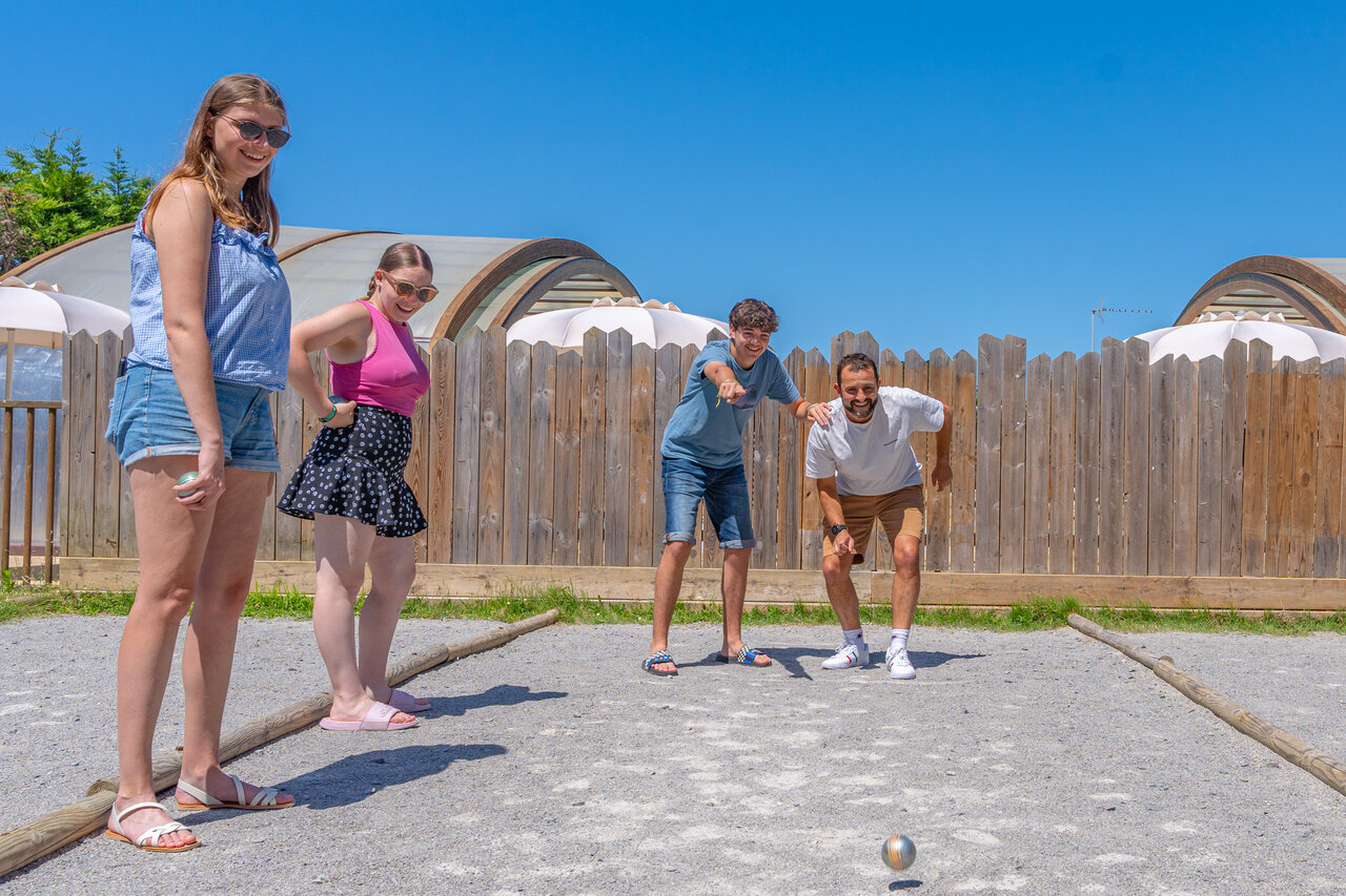 Familie speelt jeu de boules op zonnig terrein op camping CAPFUN Madrague in PORNIC (44).