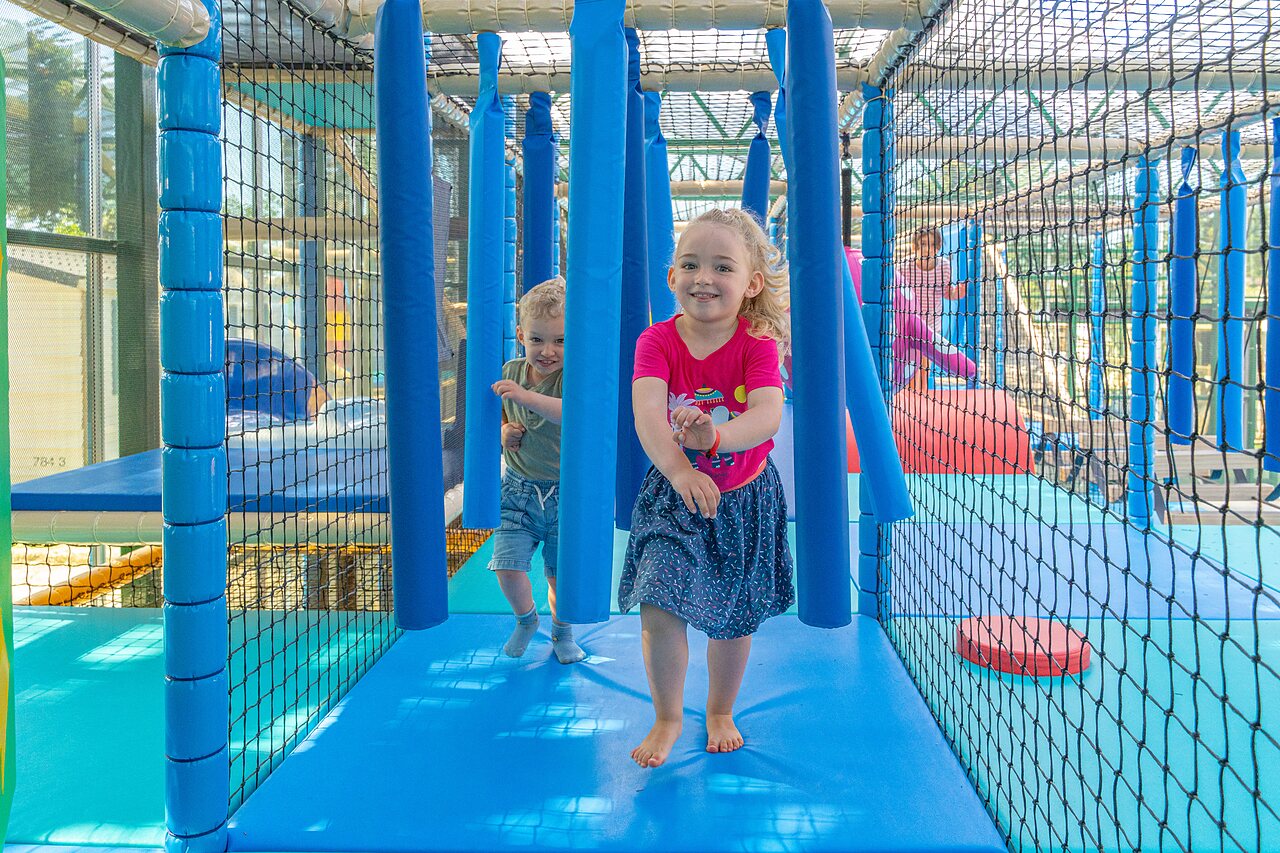 Lachende Kinder spielen in Indoor-Spielstruktur auf Campingplatz CAPFUN Madrague in PORNIC (44).