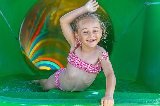 L�chelndes M�dchen auf bunter Wasserrutsche auf dem Campingplatz CAPFUN Madrague in PORNIC (44).