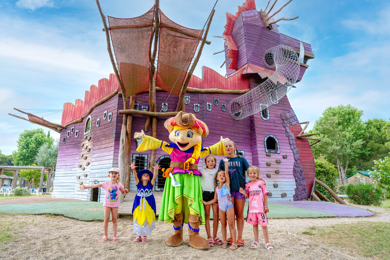Jeu Carabouille - Mascotte et enfants devant la structure de jeux dragon au CAPFUN Mael, ARGELES (66).
