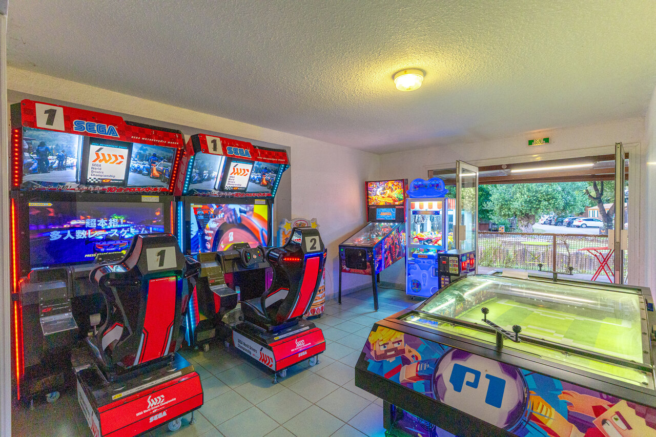 Sala de juegos con simuladores de carreras, pinball y futbol�n en el camping CAPFUN Mael en ARGELES SUR MER (66).