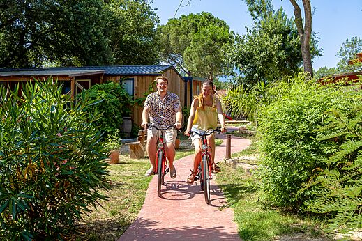 Lächelndes Paar auf Fahrrädern auf Weg des Campingplatzes CAPFUN Mael in ARGELES.
