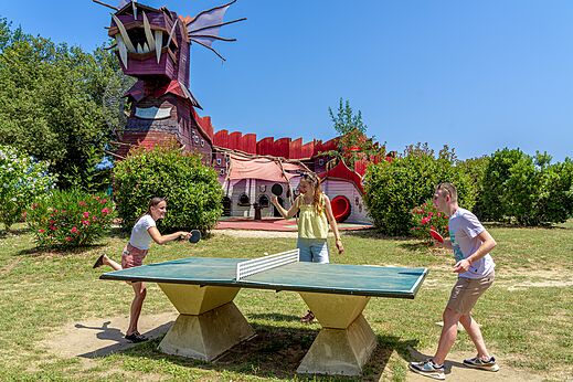 Jugendliche spielen Tischtennis vor Drachenstruktur auf Campingplatz CAPFUN Mael in ARGELES SUR MER (66).