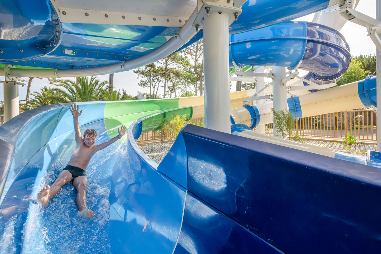 Child on giant water slide at VAGUES OCEANES Marina Landes campsite, Mimizan (40).