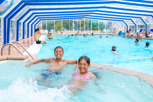 Beheiztes Hallenbad mit lachenden Kindern auf dem Campingplatz VAGUES OCEANES Marina Landes in Mimizan (40).