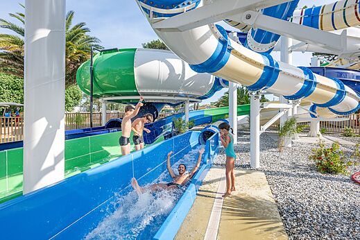 Kleurrijke waterglijbanen en kinderen die plezier hebben op camping VAGUES OCEANES Marina Landes in Mimizan (40).