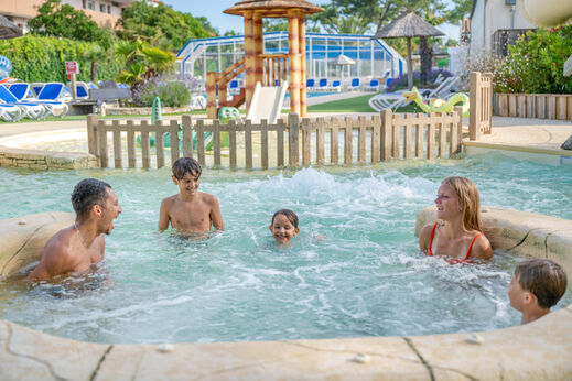Glückliche Familie im Whirlpool des Schwimmbades auf dem Campingplatz VAGUES OCEANES Marina Landes.