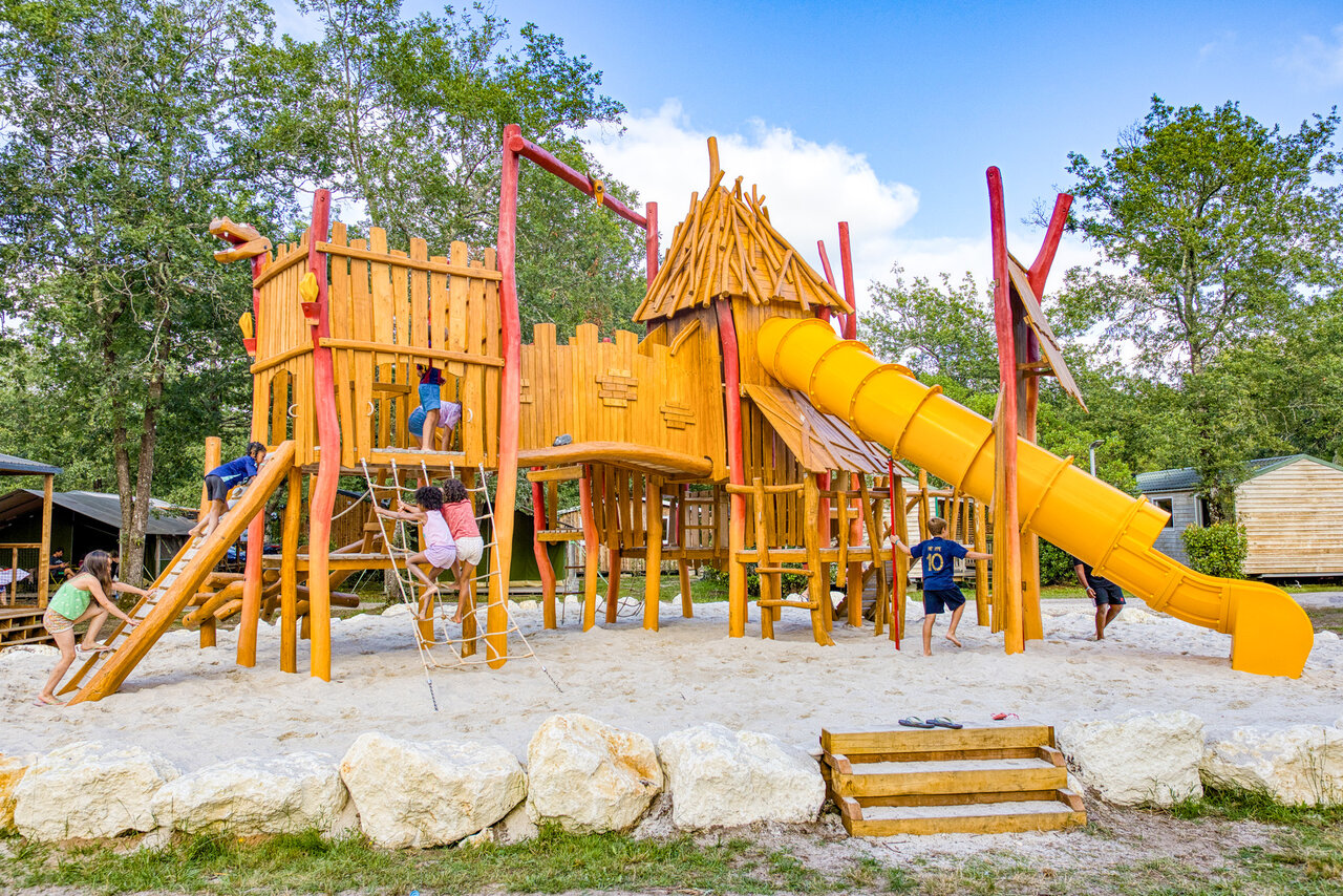 Large wooden playground with slide at CLICOCHIC campsite in Carcans.