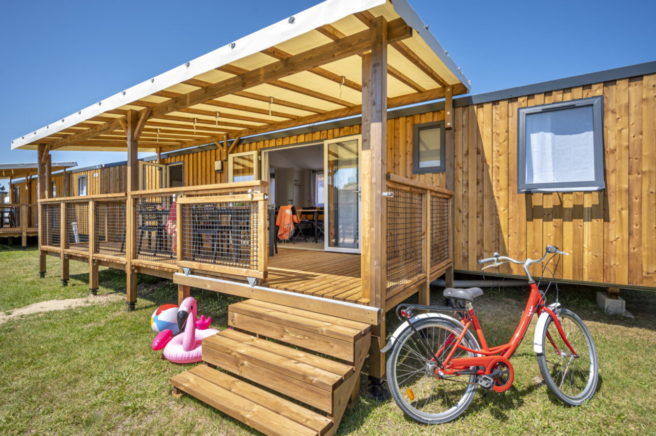 Wooden Mobile home with terrace, red bicycle at CAPFUN Mer campsite Labenne-Oc�an (40).
