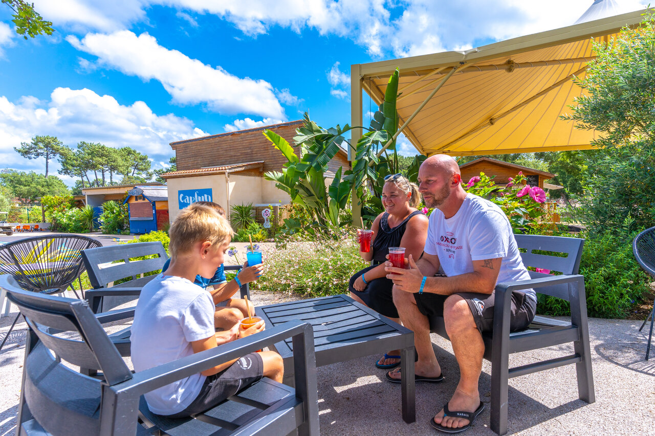Family enjoying drinks at the bar of CAPFUN Mer Labenne-Oc�an.