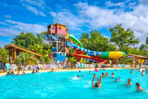 Außenpool und Wasserrutschen mit Stühlen auf dem Campingplatz CAPFUN Mer in Labenne-Océan (40).