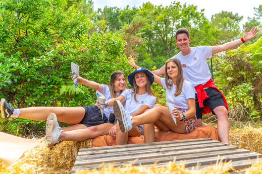 Lächelndes Animationsteam posiert draußen auf dem Campingplatz CAPFUN Mer in Labenne-Océan (40).
