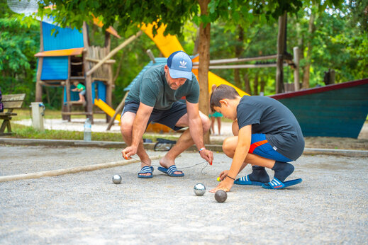 Vater und Sohn spielen Boule auf dem Campingplatz CAPFUN Mer in Labenne-Océan.