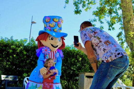 Buntes Maskottchen und Kind posieren auf dem Campingplatz CAPFUN Mer in Labenne-Océan (40).