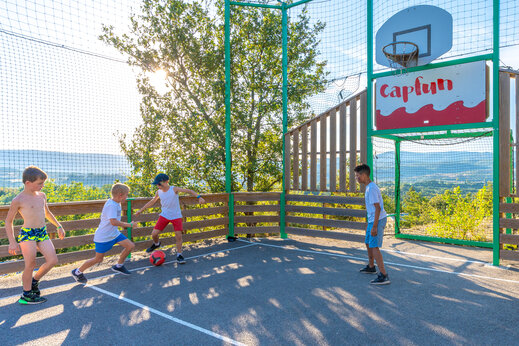 Kinder spielen Fußball auf Multisportplatz CAPFUN Merle Roux in Baix (07).