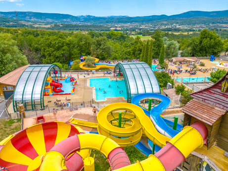 Bunte Wasserrutschen und Außenpools auf dem Campingplatz CAPFUN Merle Roux in Baix (07).