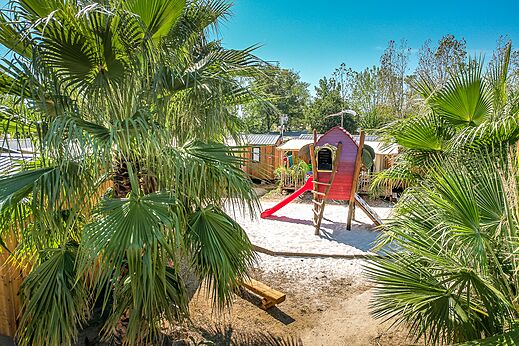 Aire de jeux avec cabane et toboggan, Mobil-homes au camping CAPFUN Mer et Soleil à Cap d'Agde (34).