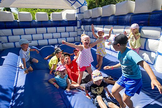 Enfants et animateur s'amusant sur un ch�teau gonflable bleu au camping CAPFUN Mer et Soleil � Cap d'Agde (34).