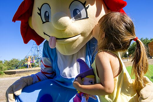 Kind knuffelt de mascotte van camping CAPFUN Mille Pépites in Carnon (34).