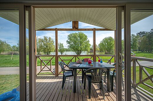 Überdachte Mobilheim-Terrasse mit Seeblick auf dem Campingplatz CAPFUN Mirabelle in VOLSTROFF (57).