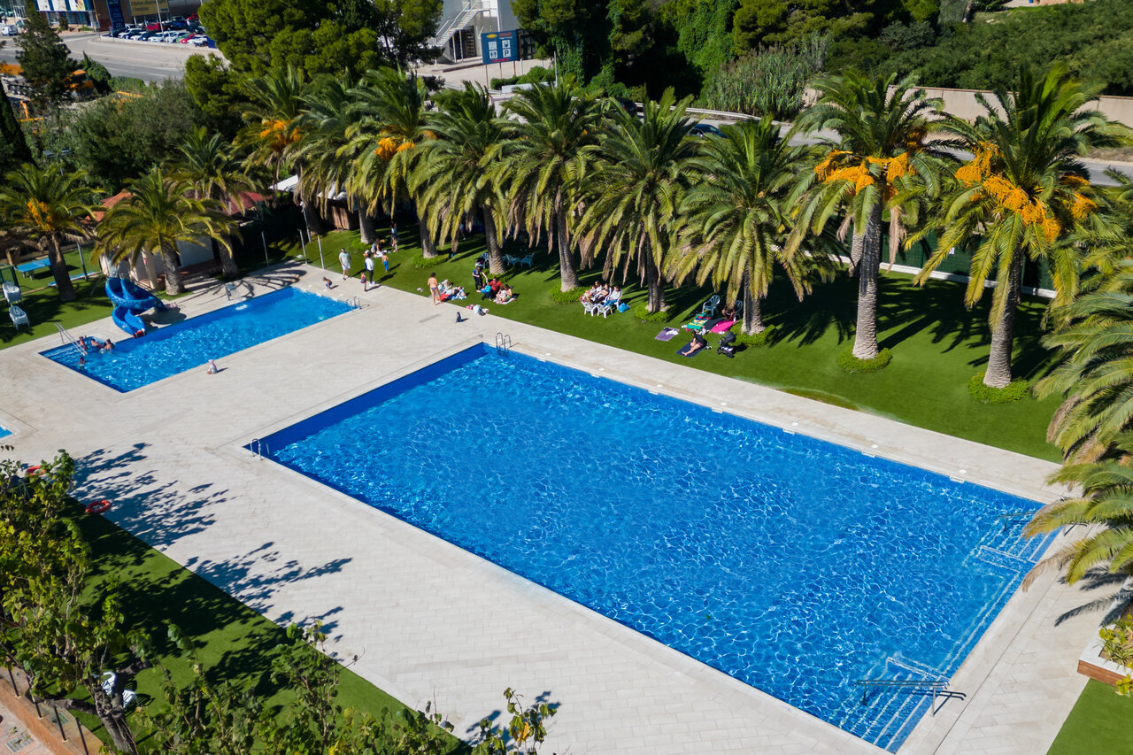 Piscinas exteriores con tobog�n y palmeras en el camping CAPFUN Mirmanda en Cambrils (43).