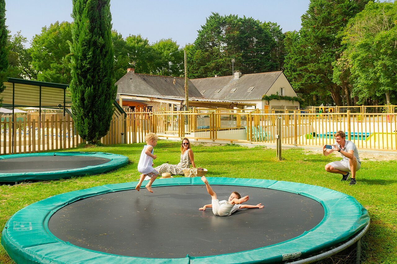 Kinder springen auf Trampolinen, Pool nah, Camping CAPFUN Montsabert, COUTURES (49).