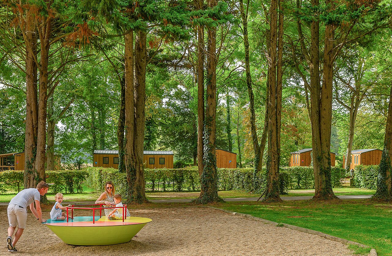 Familie spielt auf farbenfrohem Karussell, Mobilheime auf Camping CAPFUN Montsabert in COUTURES (49).