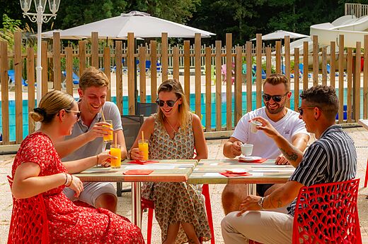 Lachende Freunde trinken an der Bar des Campingplatzes CAPFUN Montsabert in COUTURES.