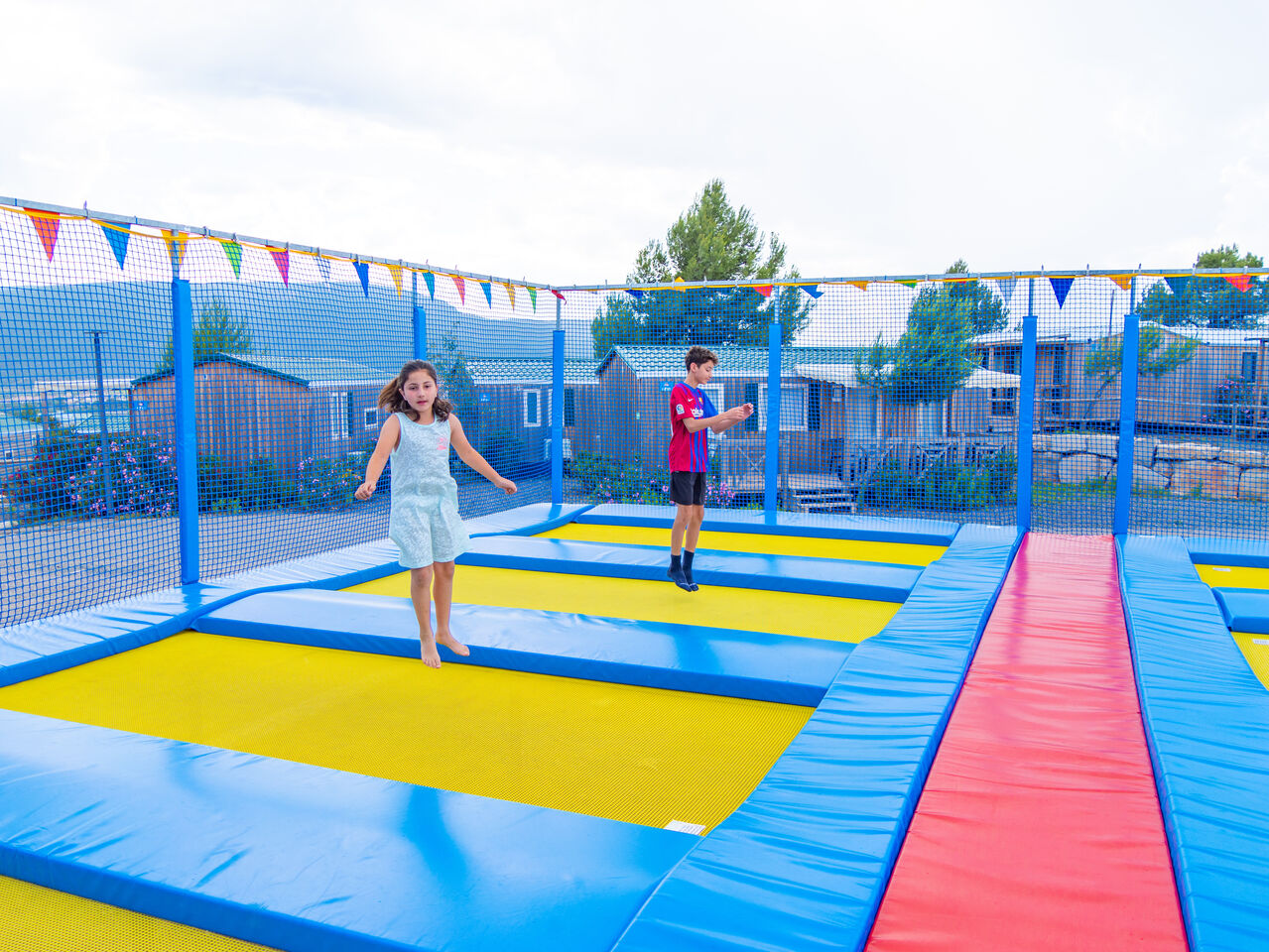 Kinder spielen auf Trampolinen, Mobilheime Hintergrund auf Campingplatz CAPFUN Montblanc Park in Montblanc (43).