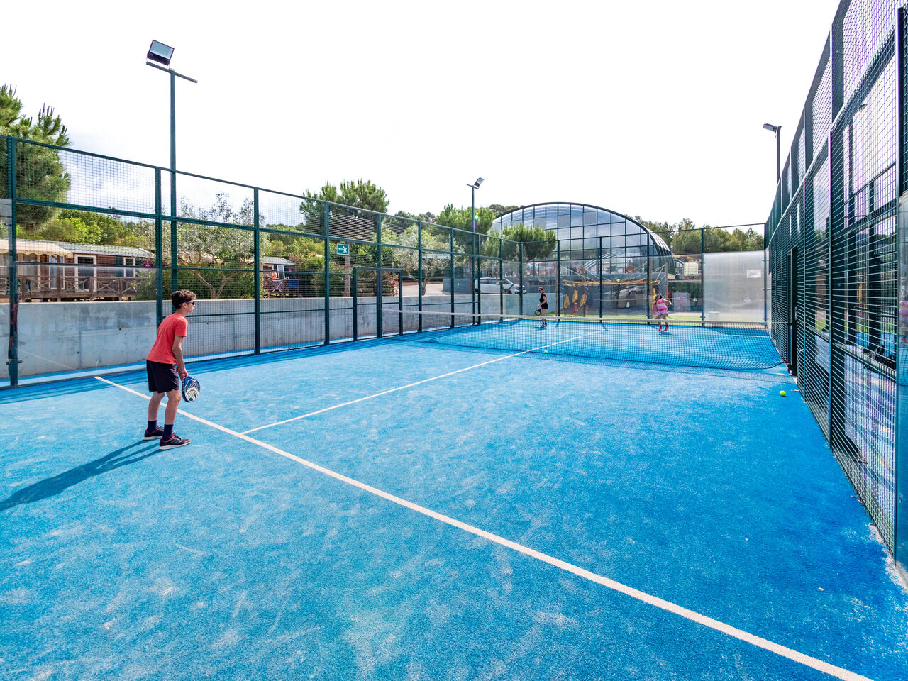 Blauer Padelplatz mit Spielern, Sportaktivit�t auf dem Camping CAPFUN Montblanc Park.