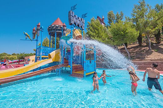 Schwimmbad mit Wasserspielen, Rutschen und Wassereimer auf dem Campingplatz CAPFUN Montblanc Park.