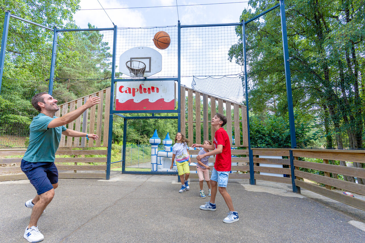 Family playing basketball on multisport court CAPFUN Moulinal campsite BIRON (24).