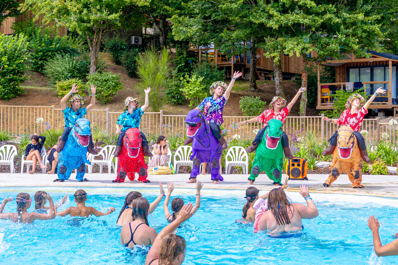 Animators in dinosaur costumes entertaining children in the swimming pool at CAPFUN Moulinal campsite in BIRON (24).
