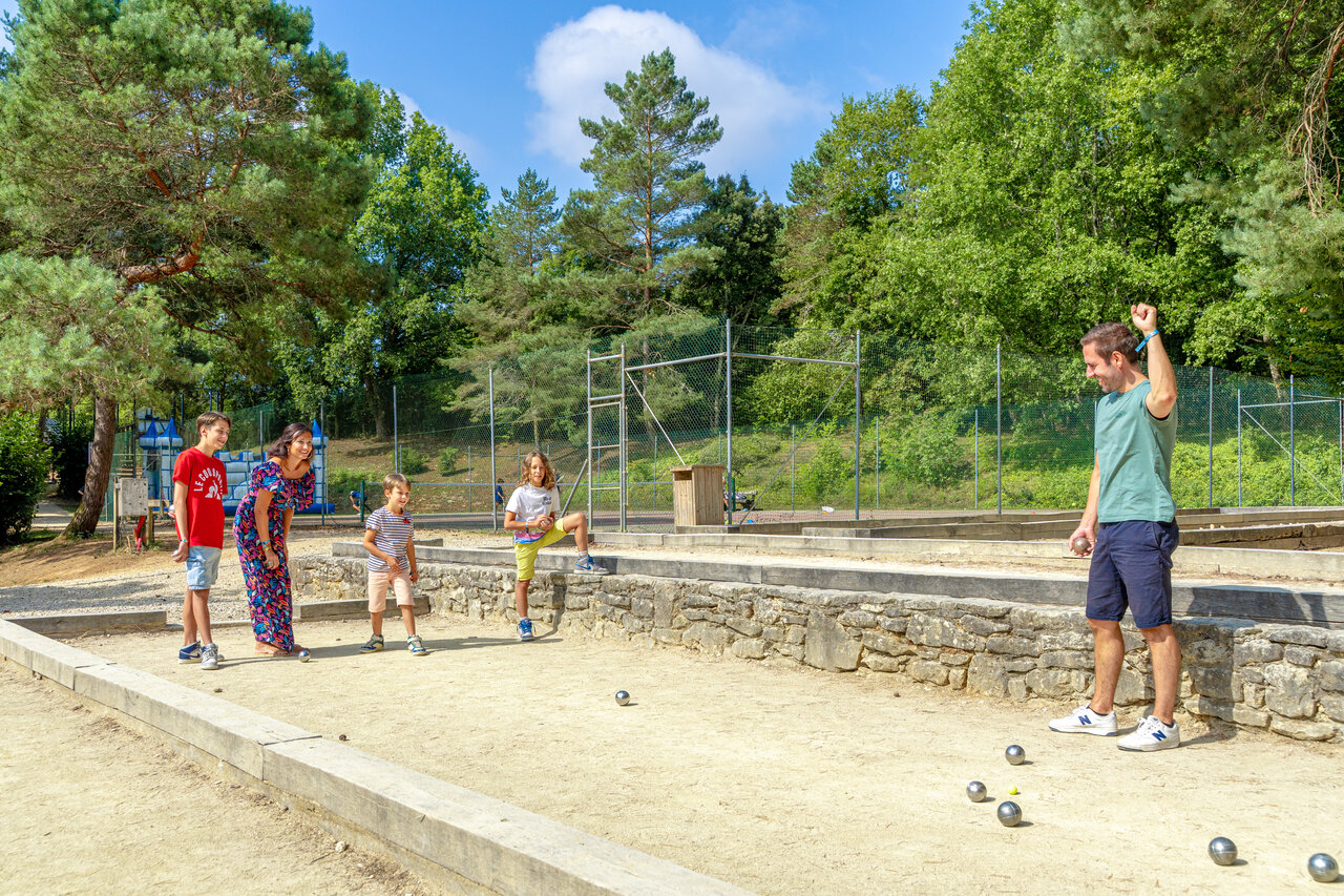 Family playing p�tanque on the court at CAPFUN Moulinal campsite in BIRON (24).